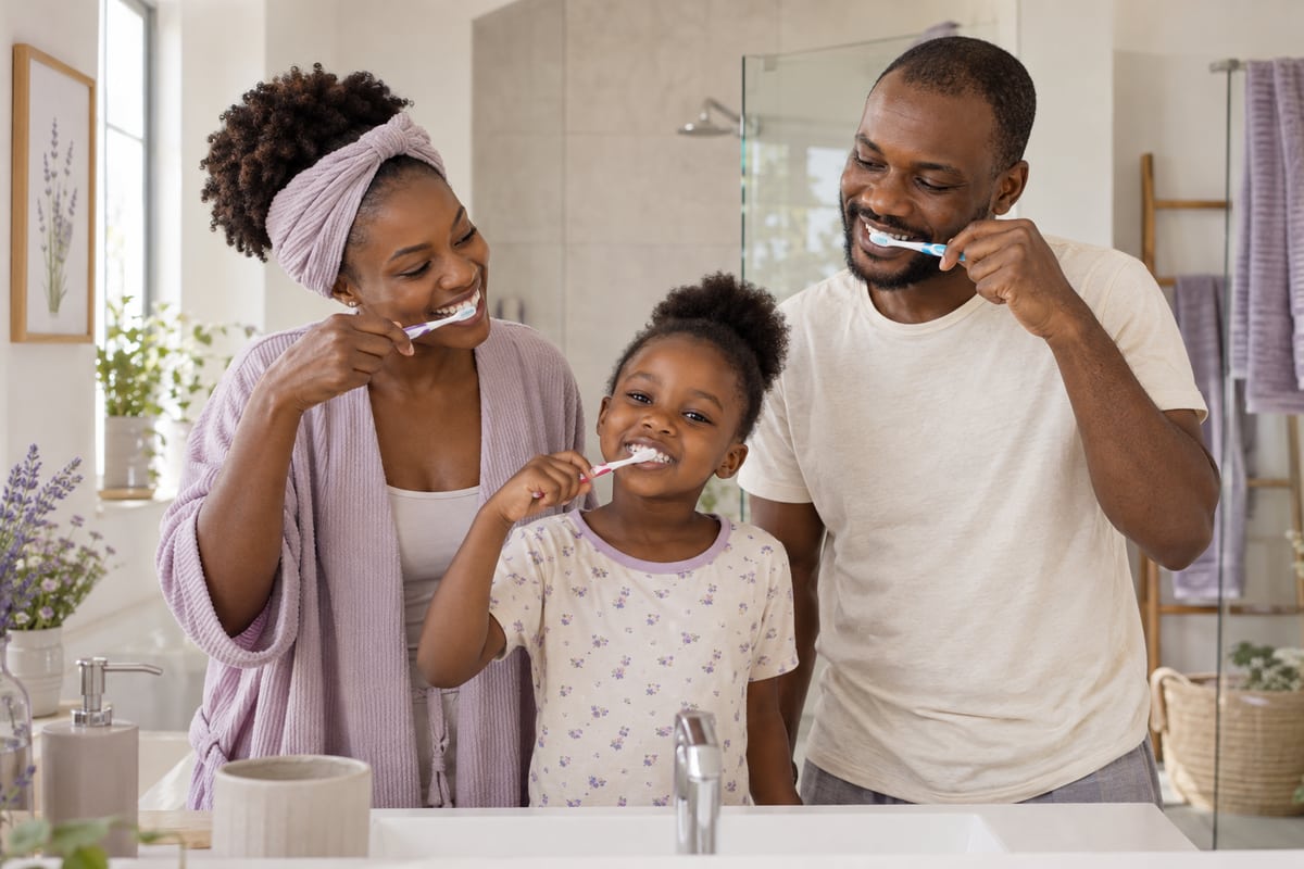 Parents et enfant se brossant les dents ensemble — image d’illustration